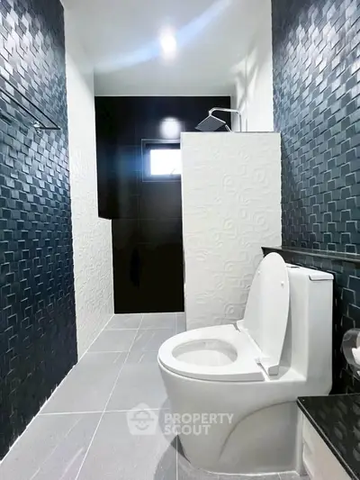 Modern bathroom with sleek black and white tiles and contemporary fixtures.