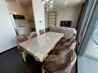 Modern dining area with granite table and wrapped chairs in a stylish apartment