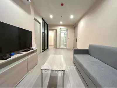Modern living room with sleek furniture and neutral tones, featuring a comfortable sofa and flat-screen TV.