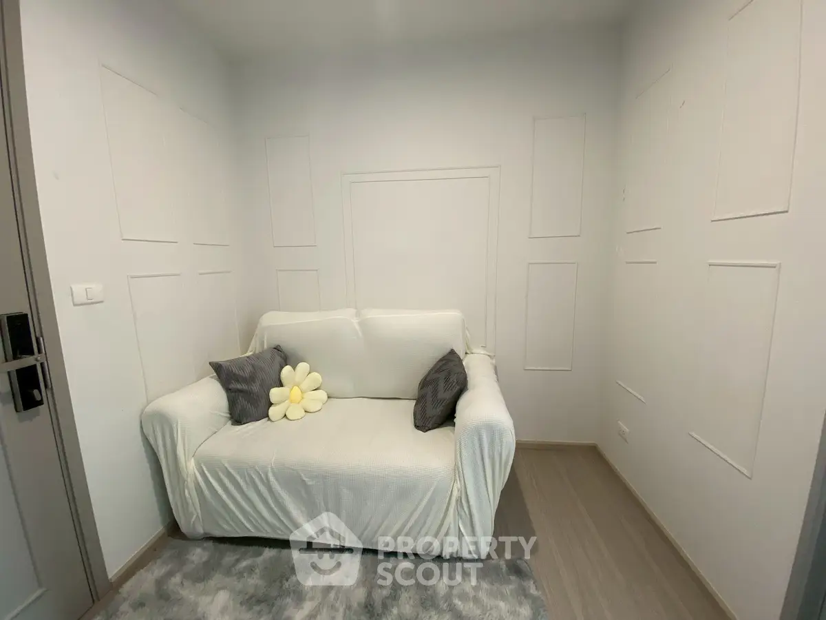 Cozy small living room with white sofa and decorative pillows, perfect for minimalist living.