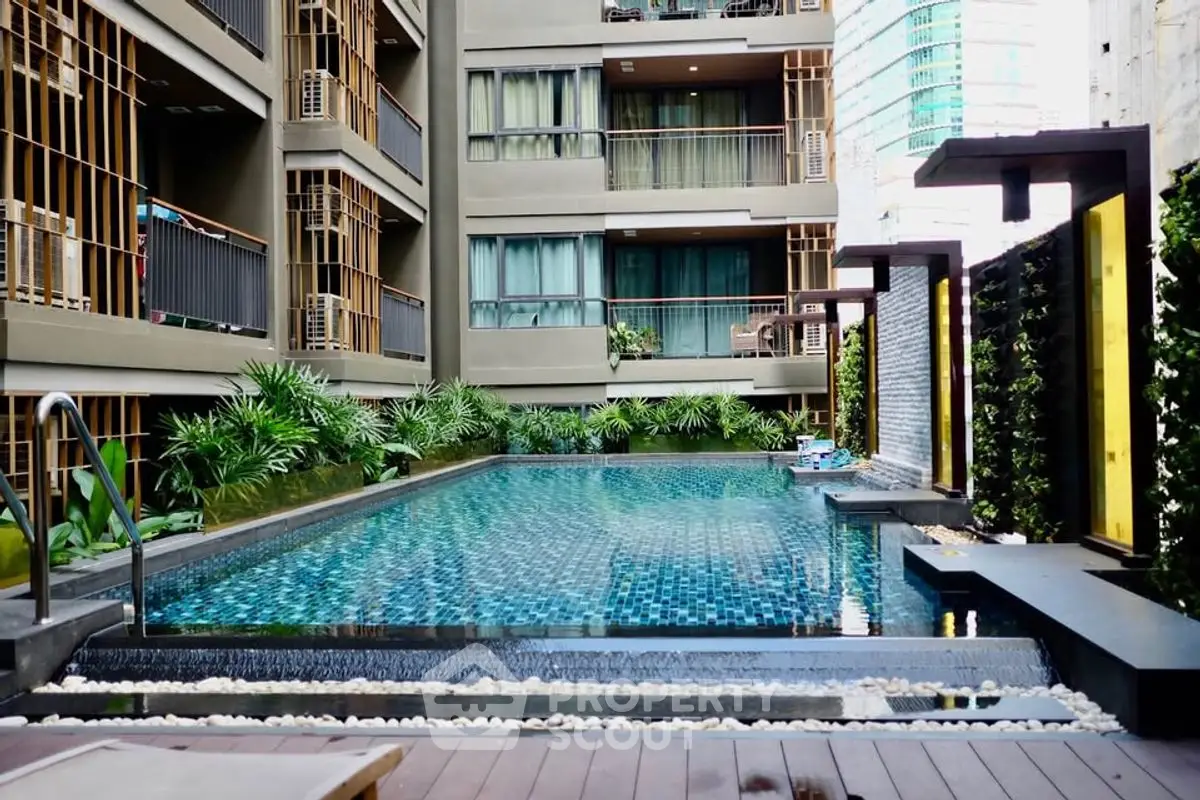 Luxurious apartment complex with a stunning outdoor pool and modern design.