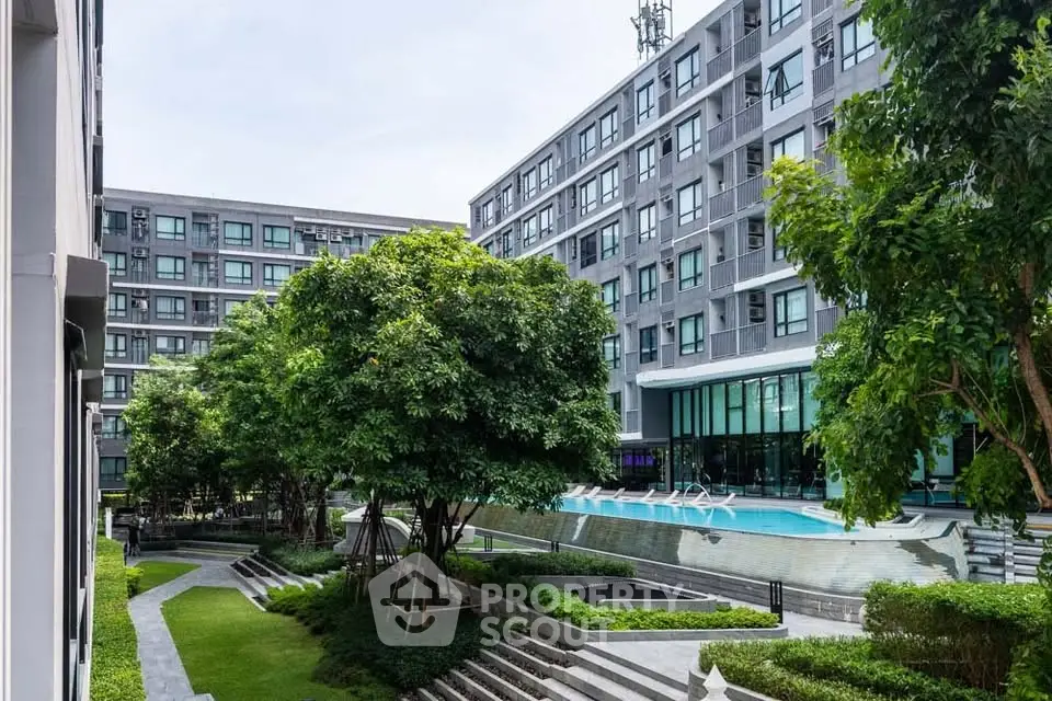 Modern apartment complex with lush garden and pool view