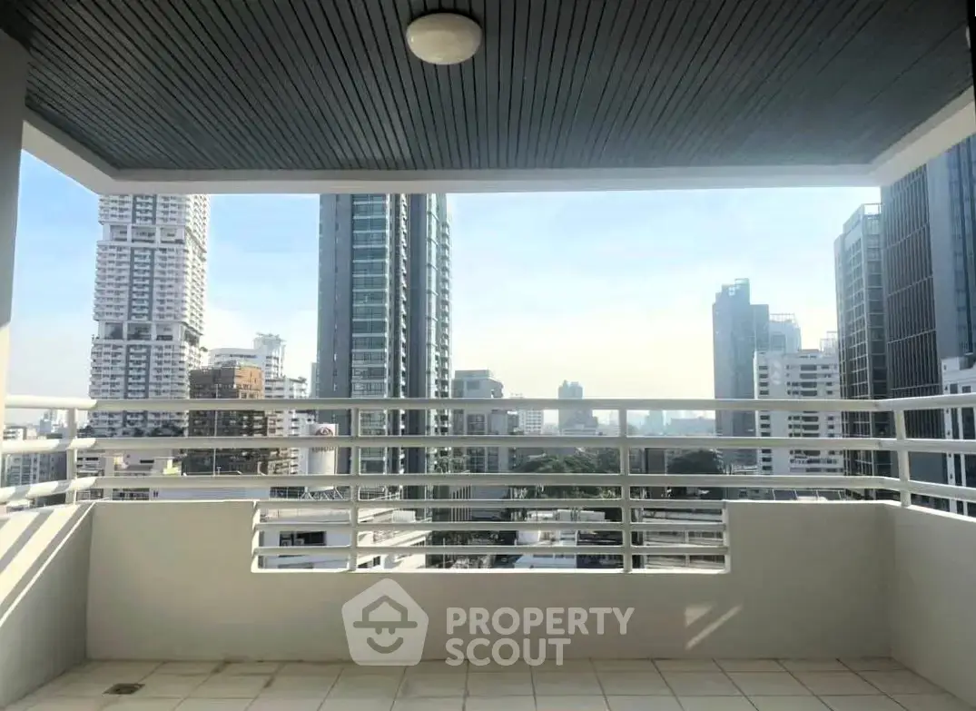 Spacious balcony with stunning city skyline view in modern high-rise building.