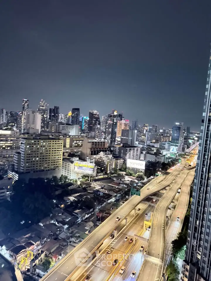 Stunning cityscape view from high-rise building at night with illuminated skyline and busy highway.