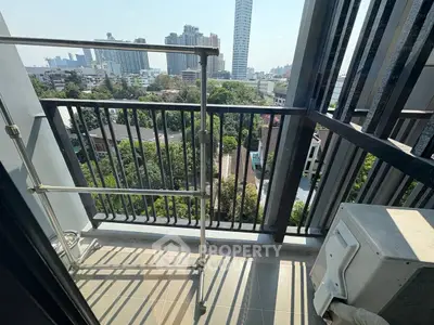 Stunning city view from a high-rise balcony with modern railing and air conditioning unit.