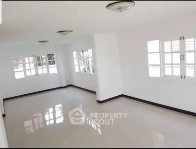 Spacious empty room with large windows and glossy tiled floor