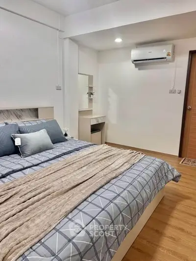 Cozy bedroom with modern decor and air conditioning in a stylish apartment.