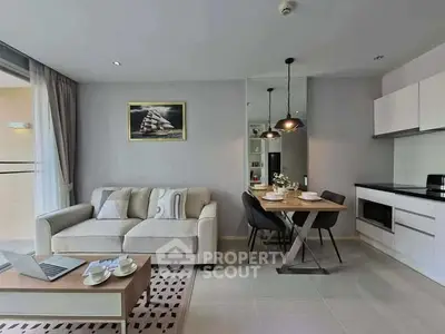 Modern living room with open kitchen, stylish decor, and cozy dining area