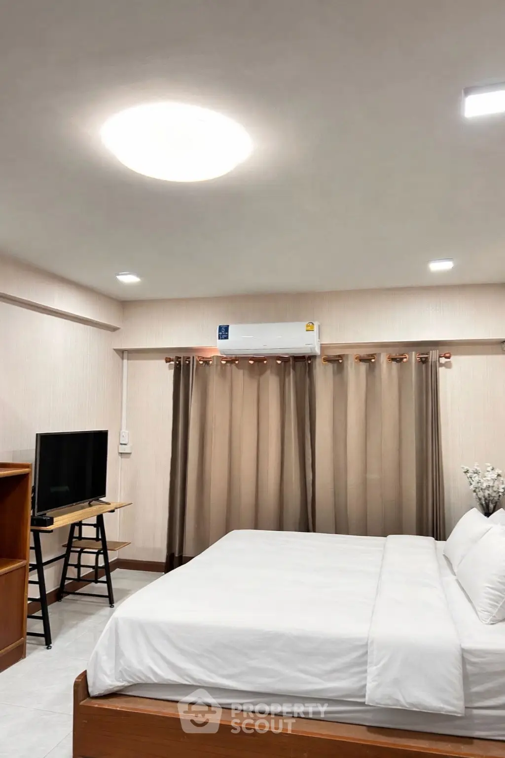 Cozy bedroom with modern decor and air conditioning, perfect for relaxation.