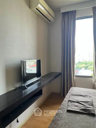 Modern bedroom with air conditioning and large window offering city views.