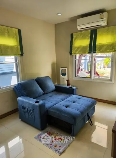 Cozy living room with blue sofa and air conditioning, perfect for relaxation.