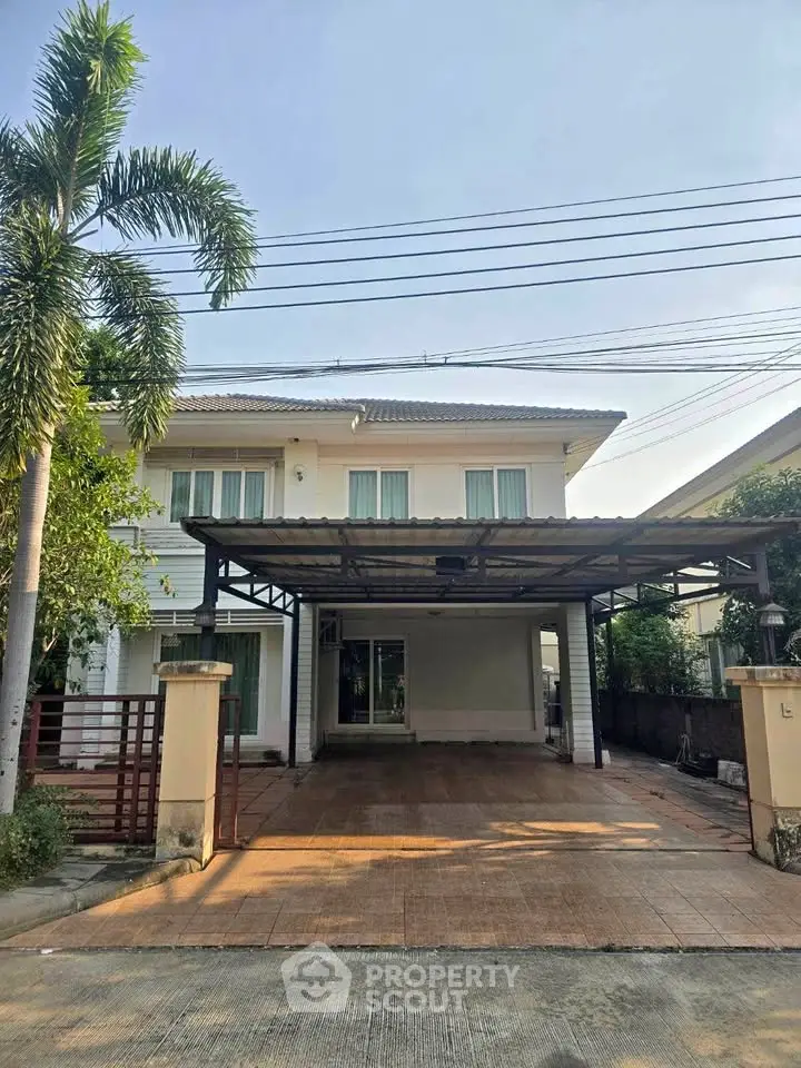 Charming two-story house with spacious driveway and lush greenery, perfect for family living.