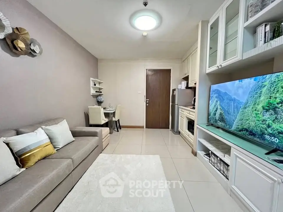 Modern living room with cozy sofa, dining area, and wall-mounted TV in stylish apartment.
