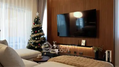 Luxurious living room with modern decor and Christmas tree, featuring a large TV and cozy seating.