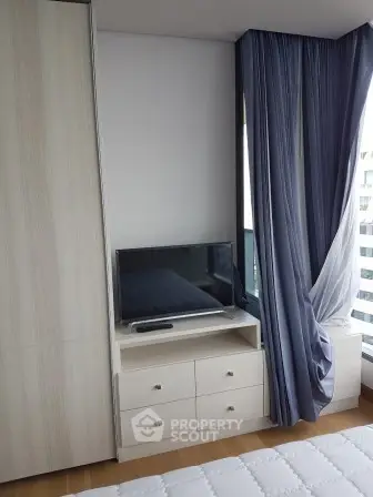 Modern bedroom with TV and stylish curtains in a cozy apartment