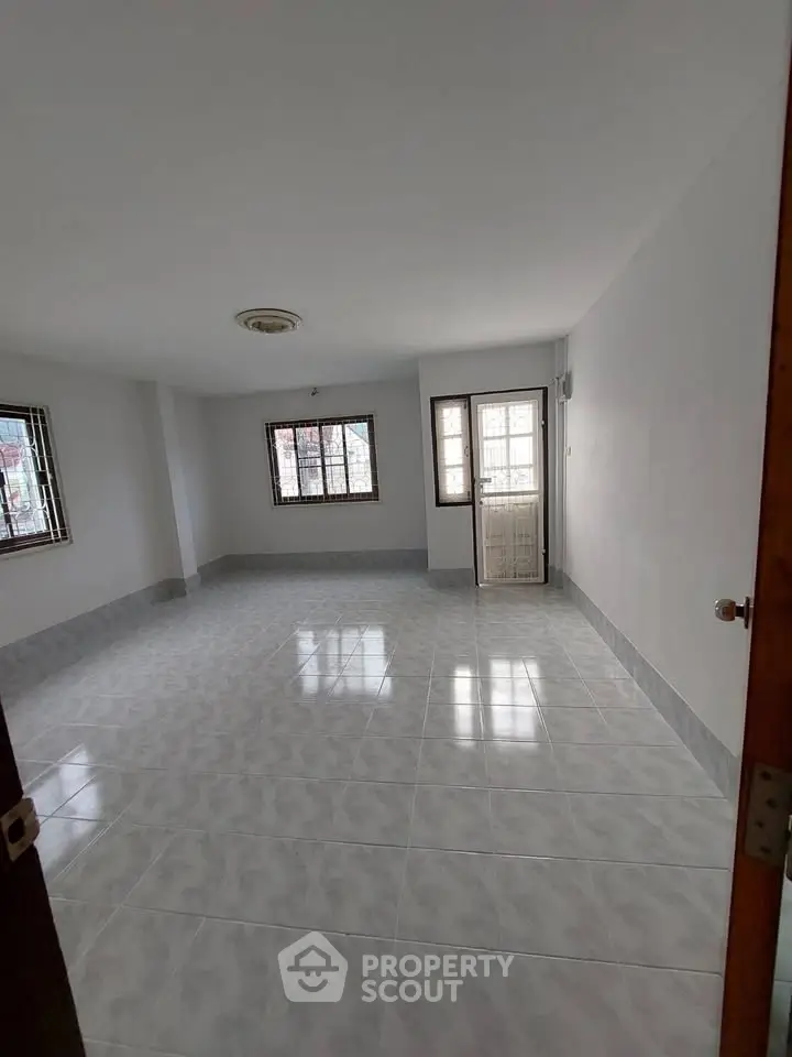 Spacious unfurnished room with tiled flooring and large windows