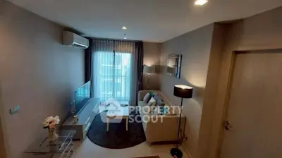 Modern living room with cozy sofa, flat-screen TV, and large window for natural light.