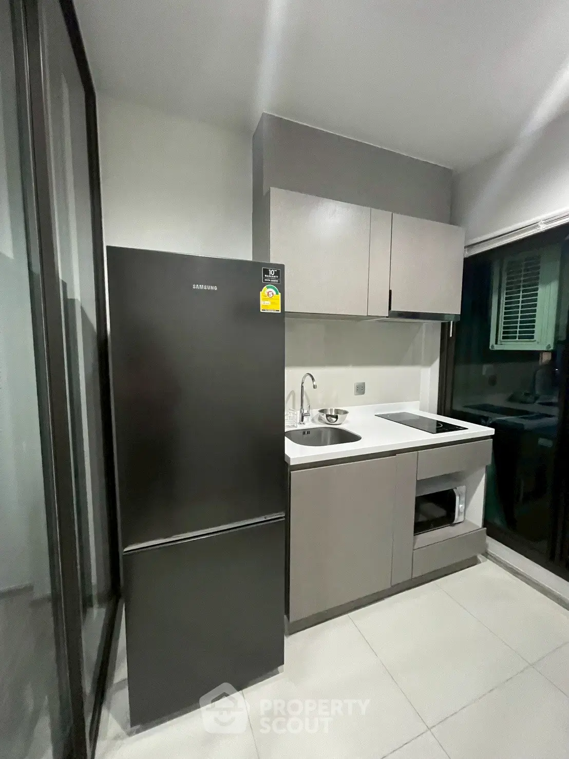 Modern kitchen with sleek cabinetry and Samsung fridge in compact layout.