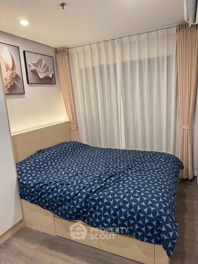 Cozy bedroom with modern decor and large window for natural light.