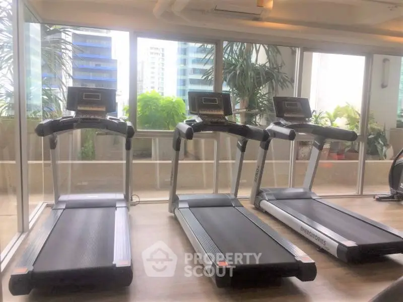 Modern gym with treadmills and city view, perfect for fitness enthusiasts seeking luxury amenities.