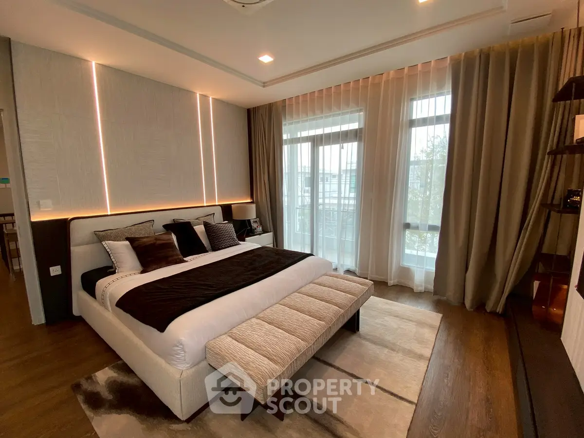 Luxurious modern bedroom with elegant decor and large windows offering natural light.