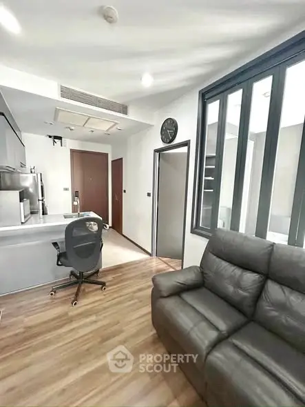 Modern living room with sleek furniture and open kitchen layout in a stylish apartment.