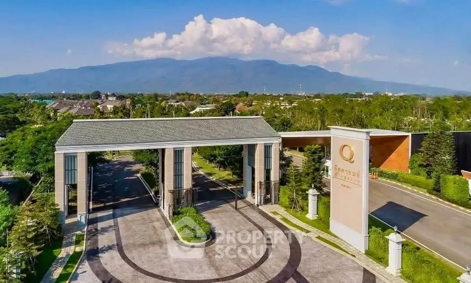 Luxurious gated community entrance with scenic mountain backdrop and lush greenery.