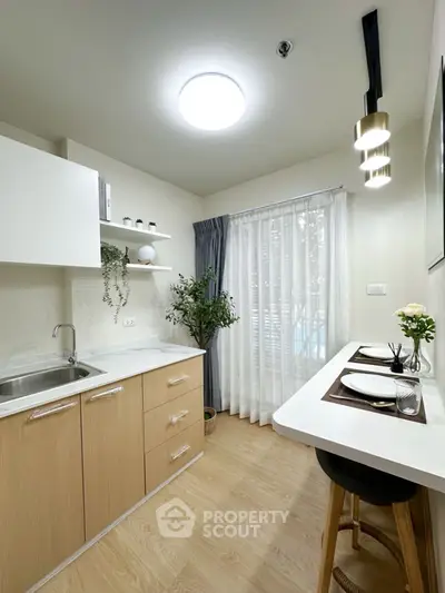 Modern kitchen with sleek design, featuring wooden cabinets and a cozy breakfast bar.