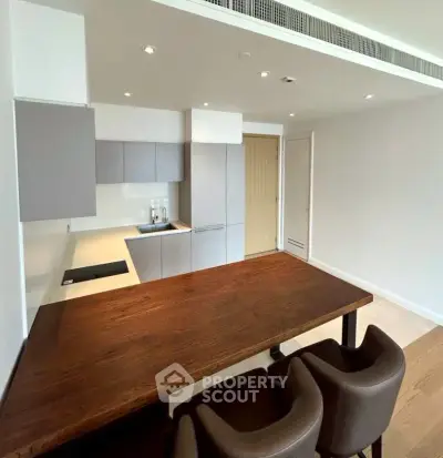 Modern kitchen with sleek cabinetry and spacious dining area in contemporary apartment.