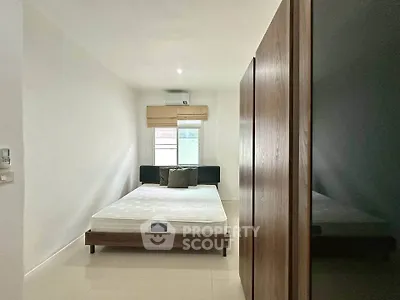 Modern minimalist bedroom with natural light and sleek furnishings.