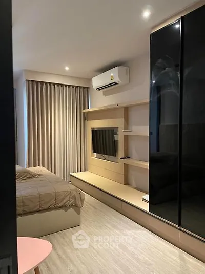 Modern bedroom with sleek design, featuring built-in TV and air conditioning.