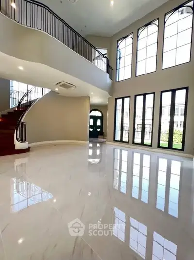 Luxurious grand entrance with high ceilings and elegant staircase in a modern home.