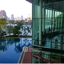 Luxurious riverside building with pool and gym offering stunning city views.