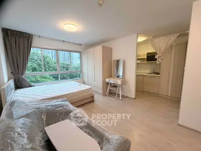 Spacious modern studio apartment with large windows and open kitchen layout, perfect for urban living.