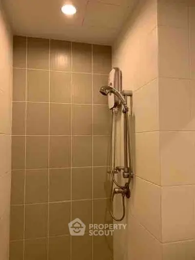 Modern bathroom shower area with sleek tiles and contemporary fixtures.