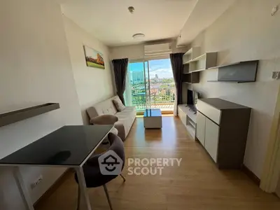 Modern living room with balcony view, stylish furniture, and natural light in urban apartment.