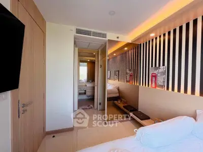 Modern bedroom with stylish decor and ensuite bathroom in a contemporary apartment.