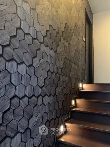 Stylish staircase with modern hexagonal wall design and ambient lighting
