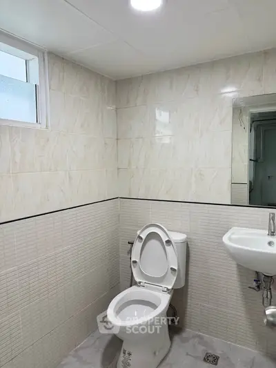 Modern bathroom with sleek tiles and compact fixtures, perfect for urban living.