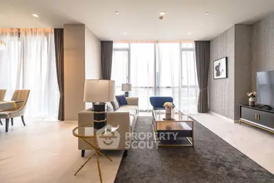 Luxurious modern living room with elegant decor and large windows offering natural light.