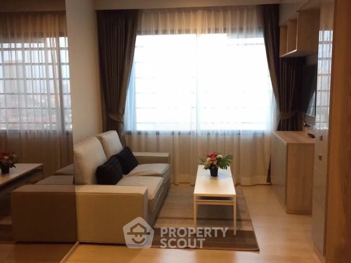 Cozy living room with modern sofa, large windows, and elegant curtains in a stylish apartment.