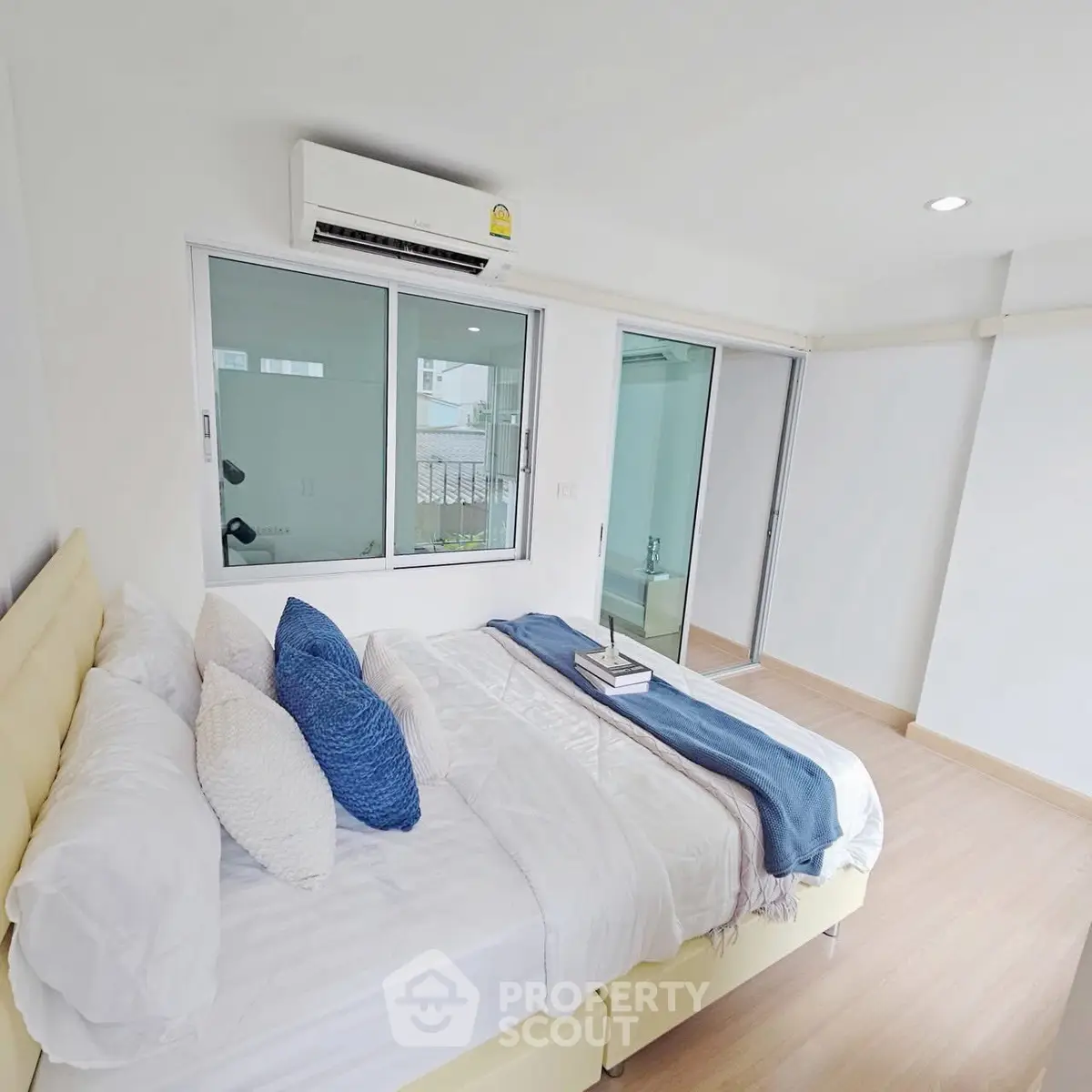 Spacious bedroom with modern decor and large window for natural light