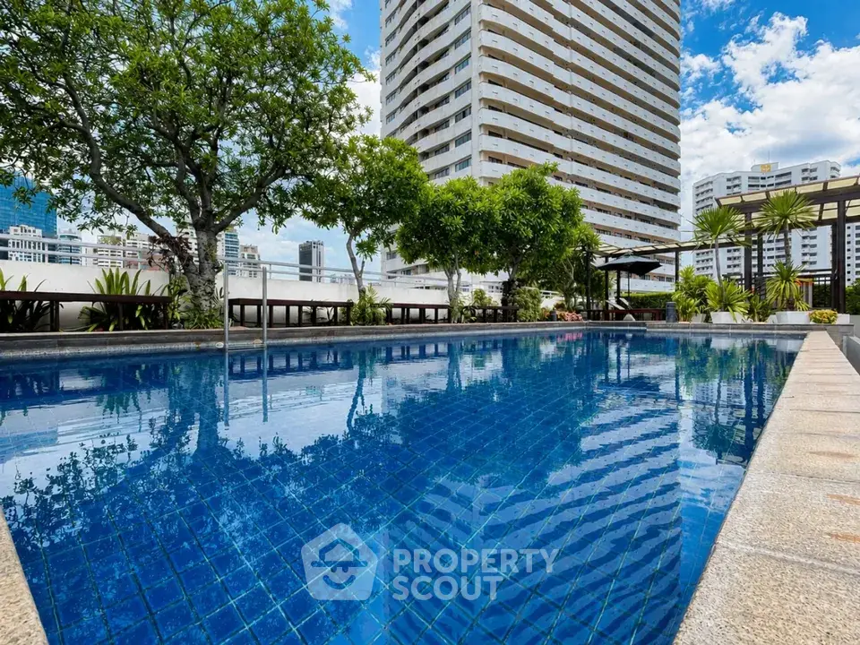 Luxurious rooftop pool with stunning city views and lush greenery, perfect for relaxation and leisure.