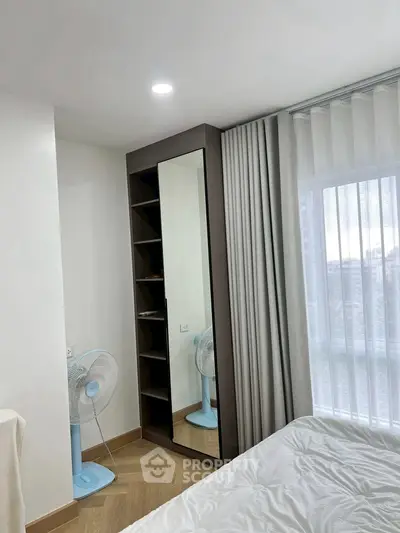 Modern bedroom with floor-to-ceiling window and sleek mirror wardrobe