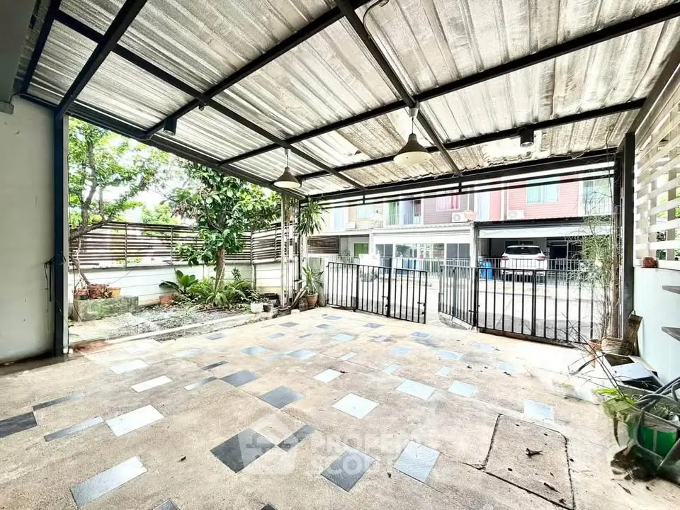 Spacious covered patio with modern design and garden view, perfect for outdoor relaxation.