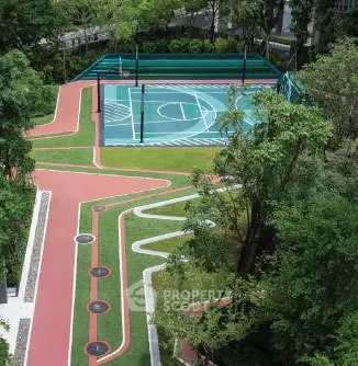 Luxurious residential complex with modern basketball court and lush greenery.
