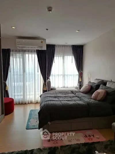 Cozy bedroom with large windows and modern decor in a stylish apartment.