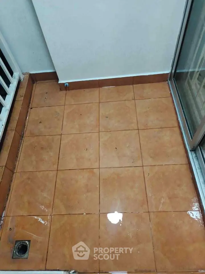 Cozy balcony with tiled floor and sliding glass door, perfect for small outdoor space.