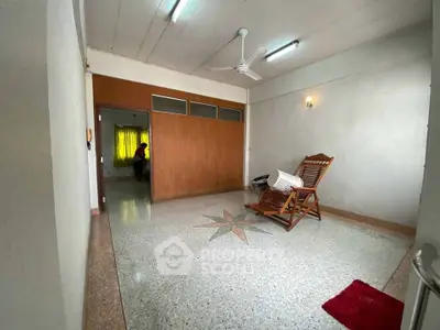 Spacious living room with unique floor design and wooden chair, ideal for relaxation.
