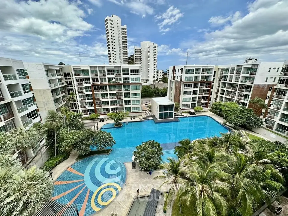 Luxurious residential complex with a large pool and lush greenery, offering a serene urban oasis.